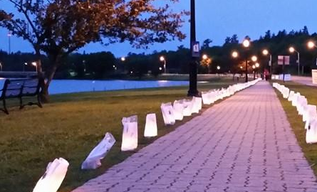 sidewalk along harbourfront lined with glowing candles 